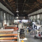 The inside of a metal fabrication shop, a fork lift drives down the center of the space