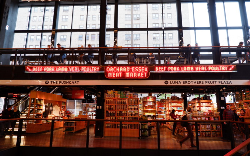 The first and second floors of the Essex Market with a historic neon sign from the Orchard Essex Meat Market