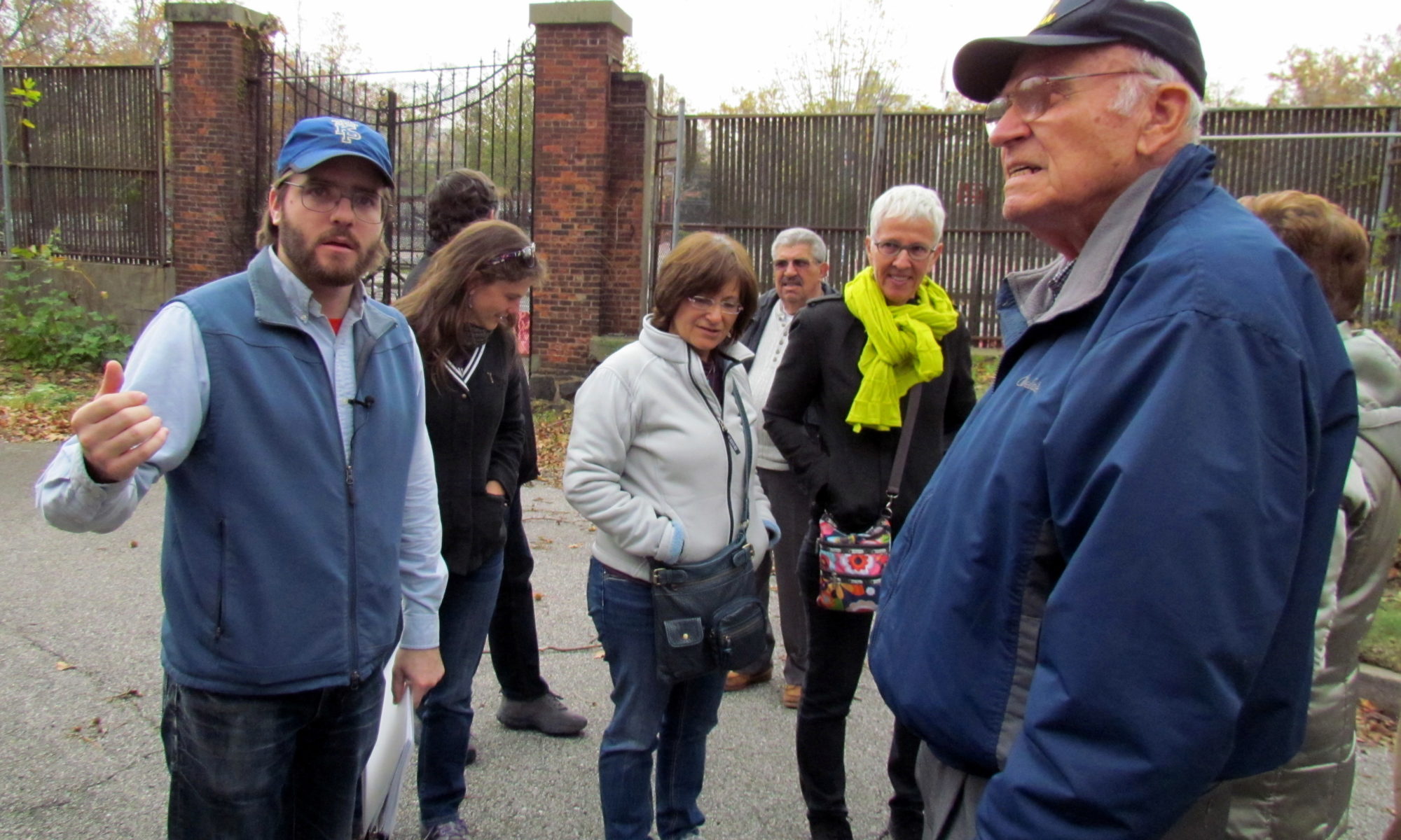 Tour group standing in front of the gates of the Commandant's House with WWII veteran Paul Mager standing on the right.