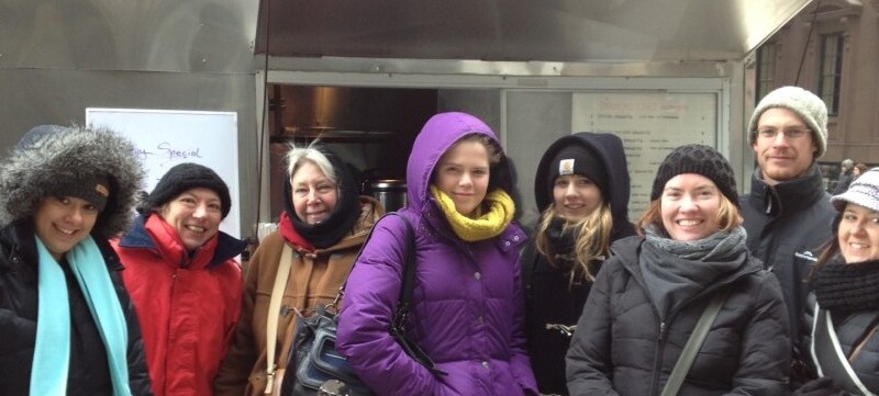 Visitors standing in front of food cart in winter