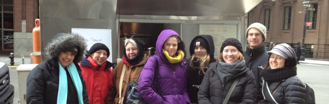 Visitors standing in front of food cart in winter