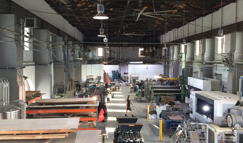 The inside of a metal fabrication shop, a fork lift drives down the center of the space
