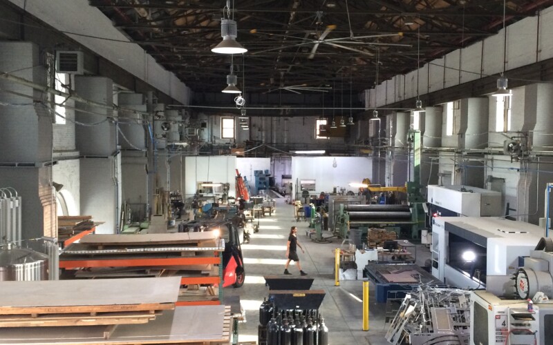 The inside of a metal fabrication shop, a fork lift drives down the center of the space