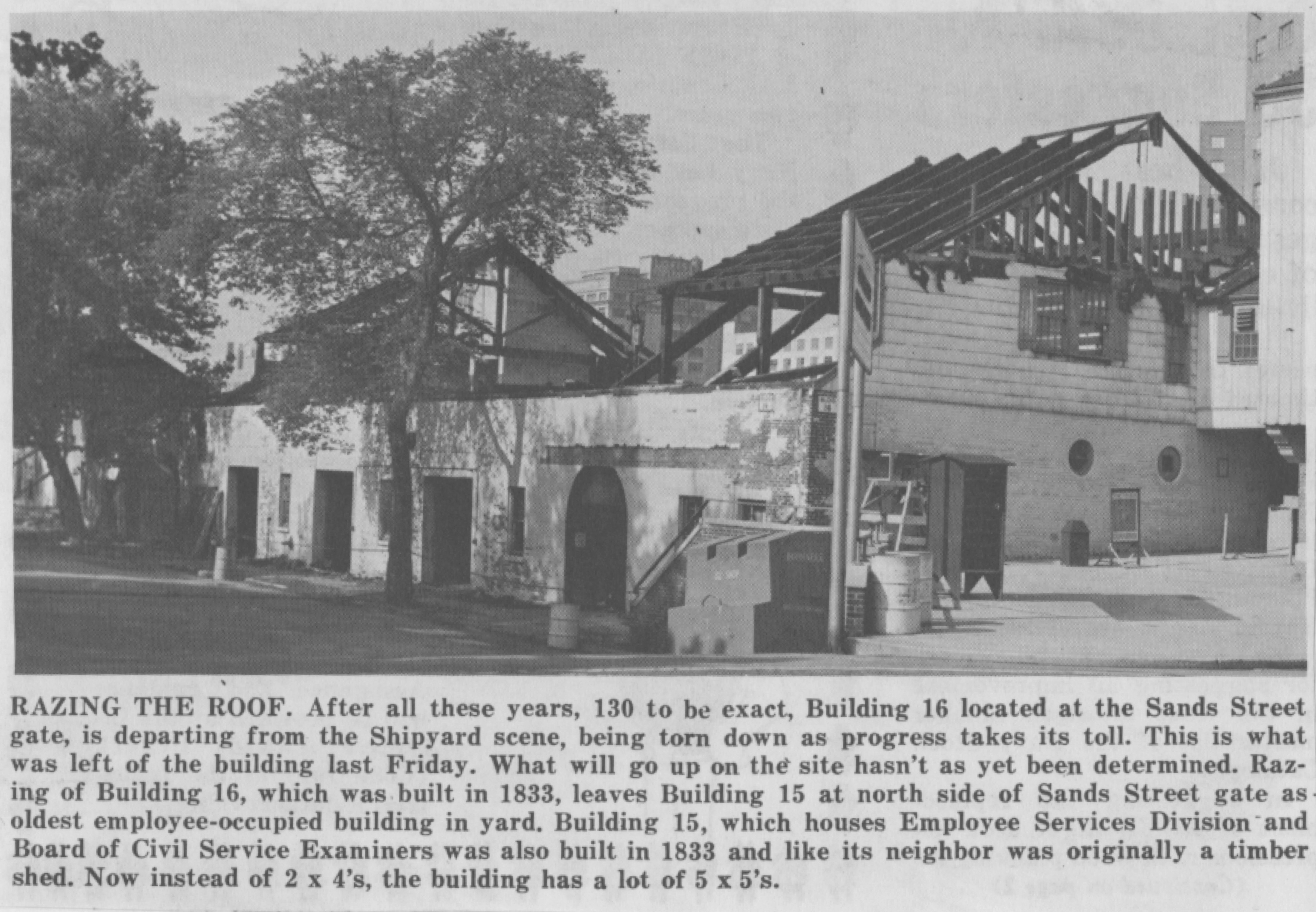 Newspaper clipping with photograph showing the Timber Shed with its roof partially demolished.