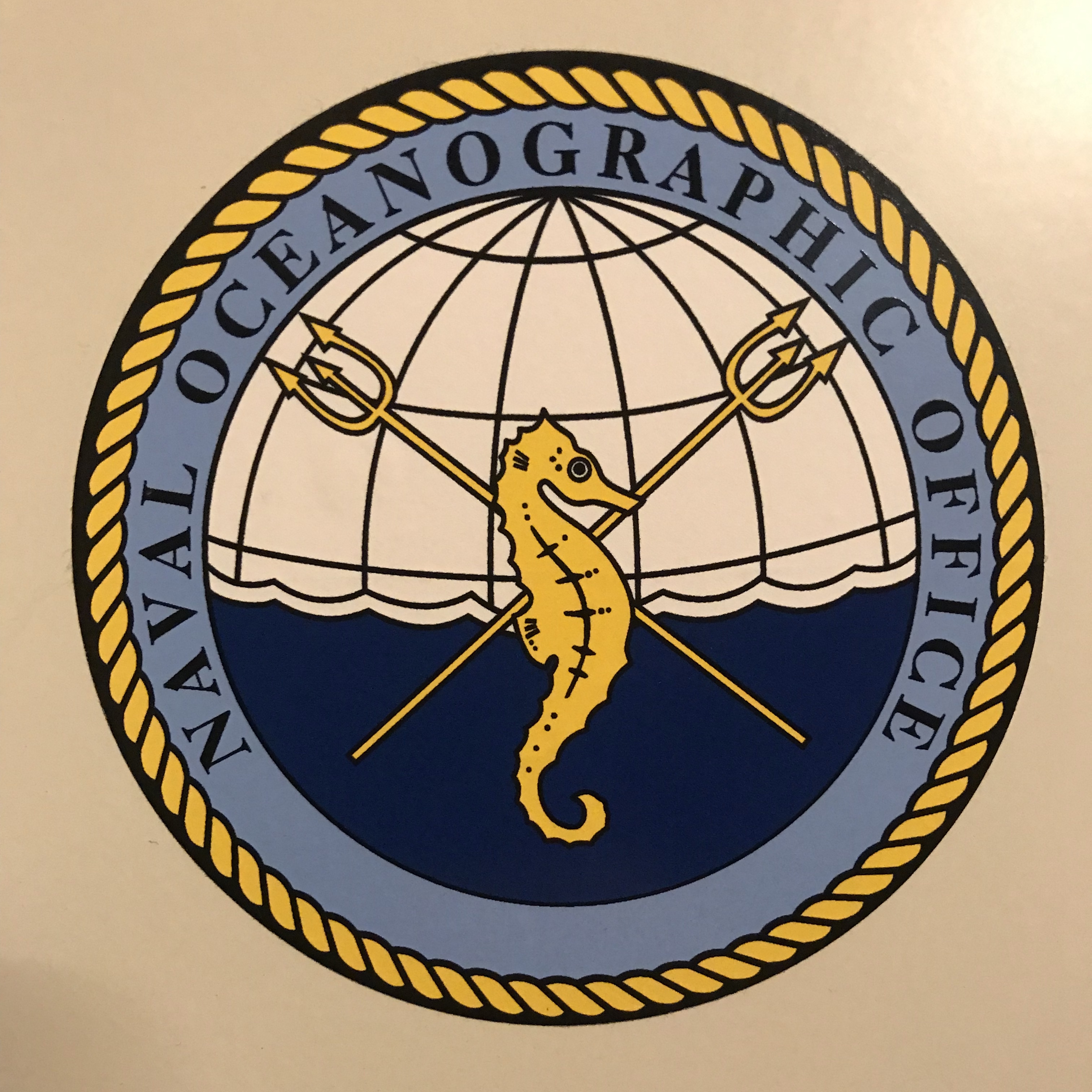 Circular logo with yellow seahorse and two yellow tridents