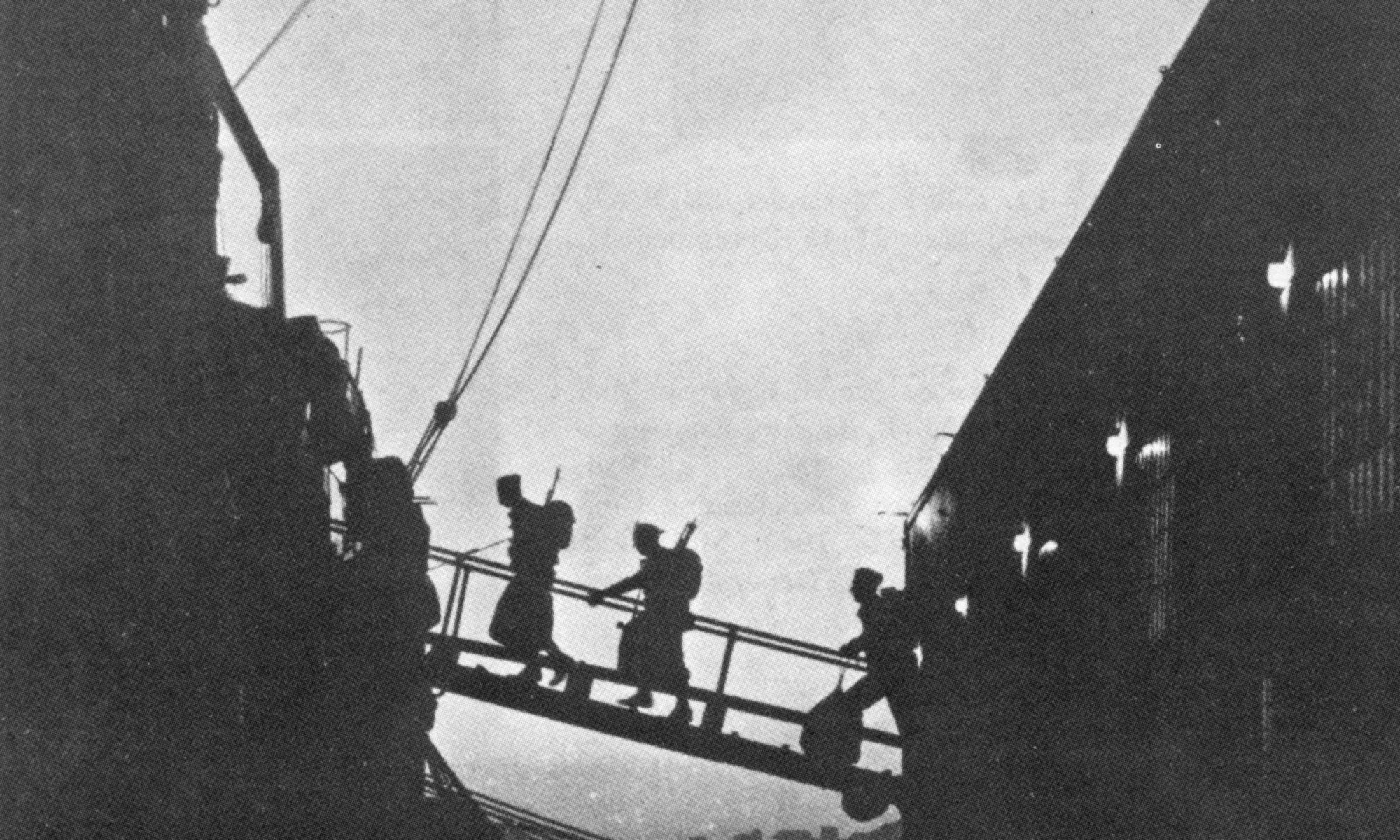 Black and white photo of two soldiers walking up a gangplank onto a ship at dusk.