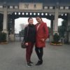 Two women standing front of a structure with Chinese characters